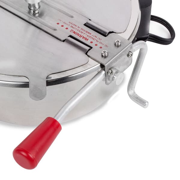 A close up of a stainless steel Carnival King kettle with a red handle.