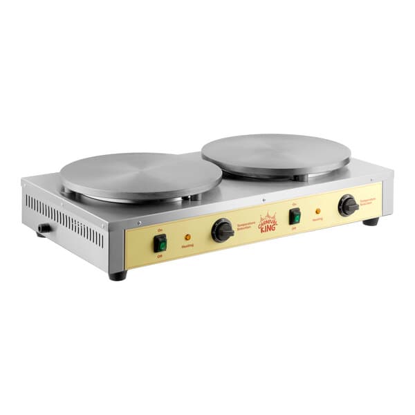 A dual steel crepe maker with two large round cooking surfaces and control knobs on the front panel.