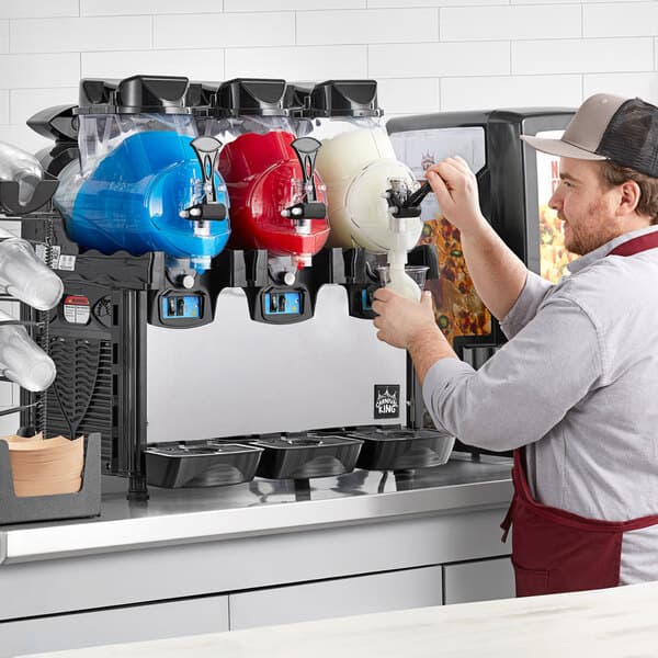 A man working at a Carnival King frozen beverage dispenser.