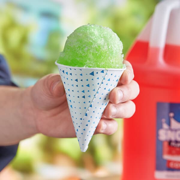 A hand holding a Carnival King paper cone filled with green ice cream.
