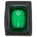 A green light switch with a white circle and green push button with the number one.