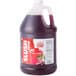 A jug of Carnival King Cherry Slushy Concentrate on a counter.