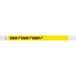 A yellow Tyvek wristband with black text that reads "STAFF"