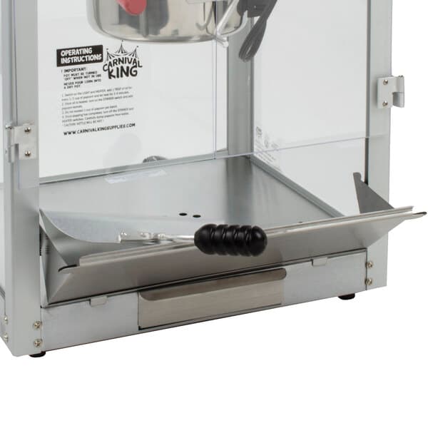 A close-up of a metal drop door with a handle for a Carnival King popcorn machine.