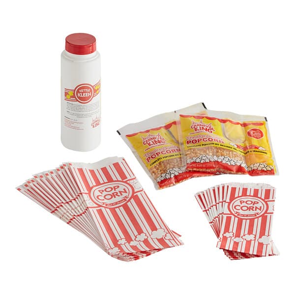 A stack of red and white popcorn bags with a container of popcorn.