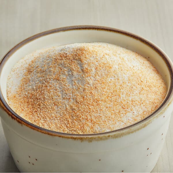 A bowl of Carnival King Savory Garlic Popcorn Seasoning powder.