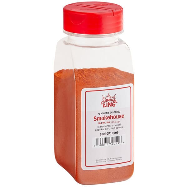 A plastic container of Carnival King Smokehouse Popcorn Seasoning with a red lid and red powder inside.