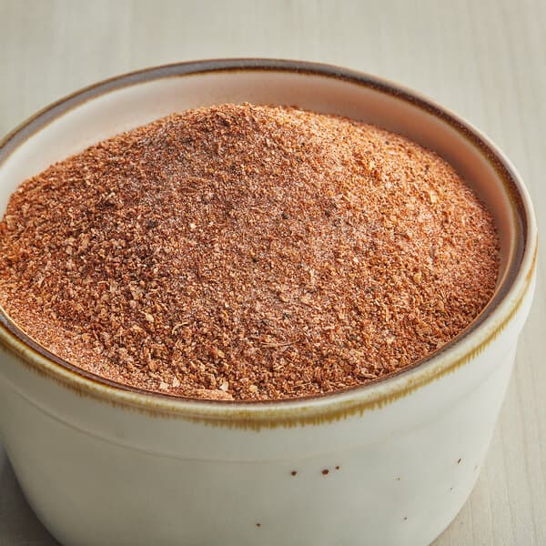A white bowl of Carnival King Kickin' Cajun Popcorn Seasoning.