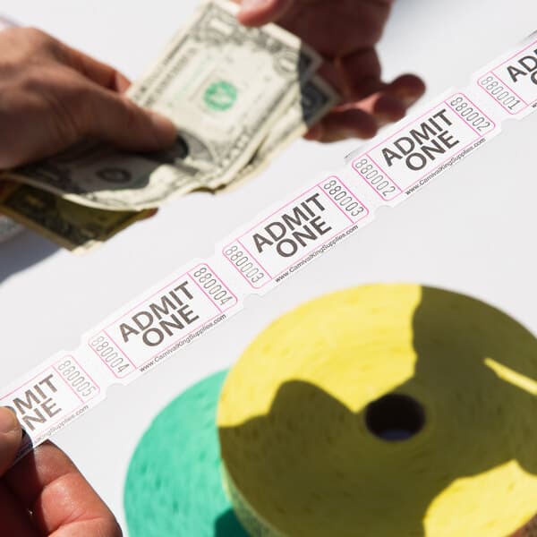 A person holding a Carnival King "Admit One" ticket and money.